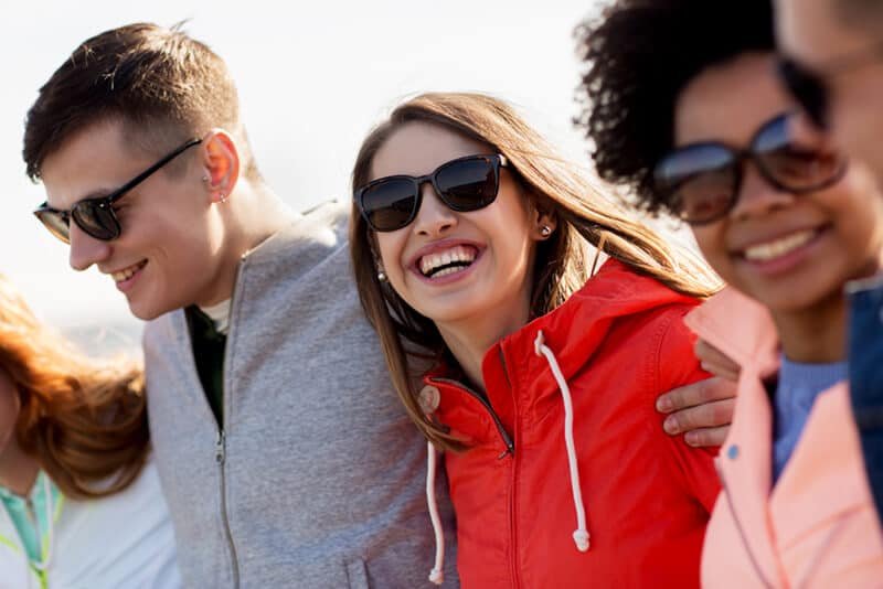 happy teenage friends in shades talking on street pgfdgf6 1024x683